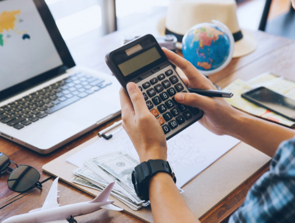 Adult Using Calculator in Budgeting Travel Expenses