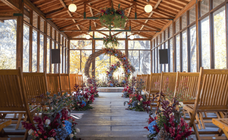 Enclosed wooden wedding venue with floral arch